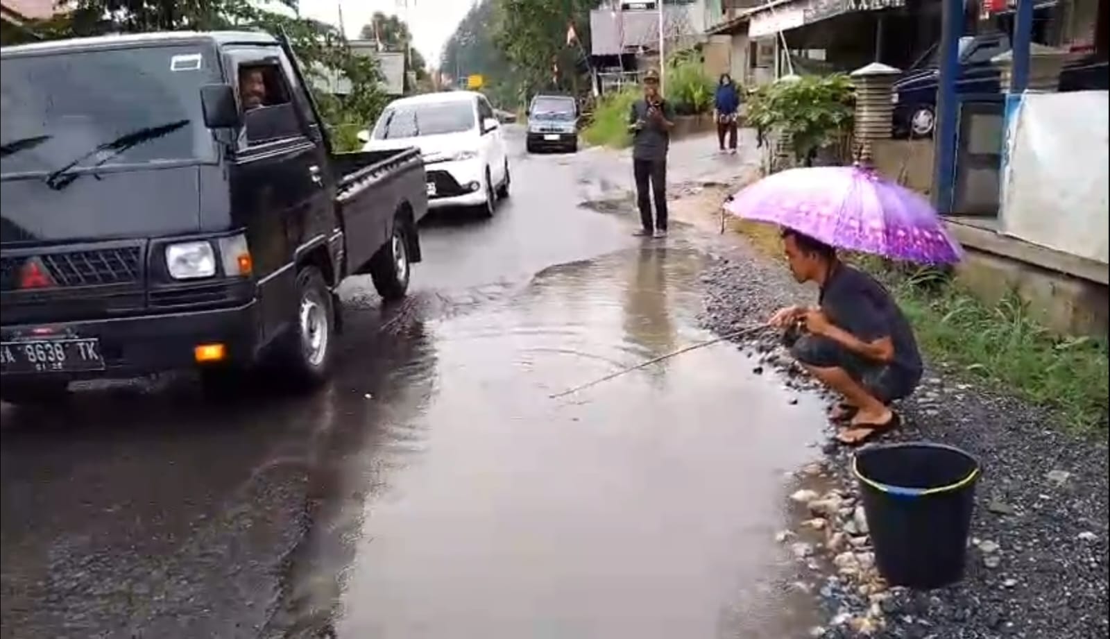 Aksi mancing warga di jalan Raya Payakumbuh-Lintau yang rusak parah